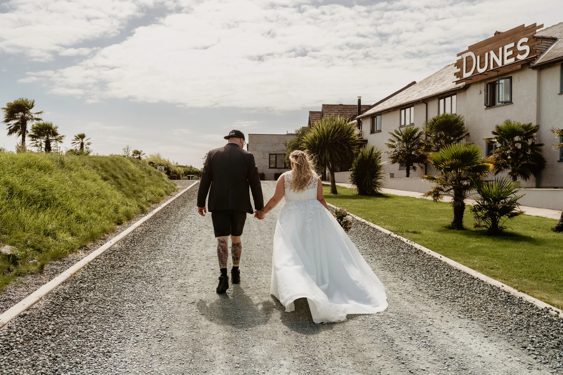 A couple walking up the drive towards The Dunes Hotel