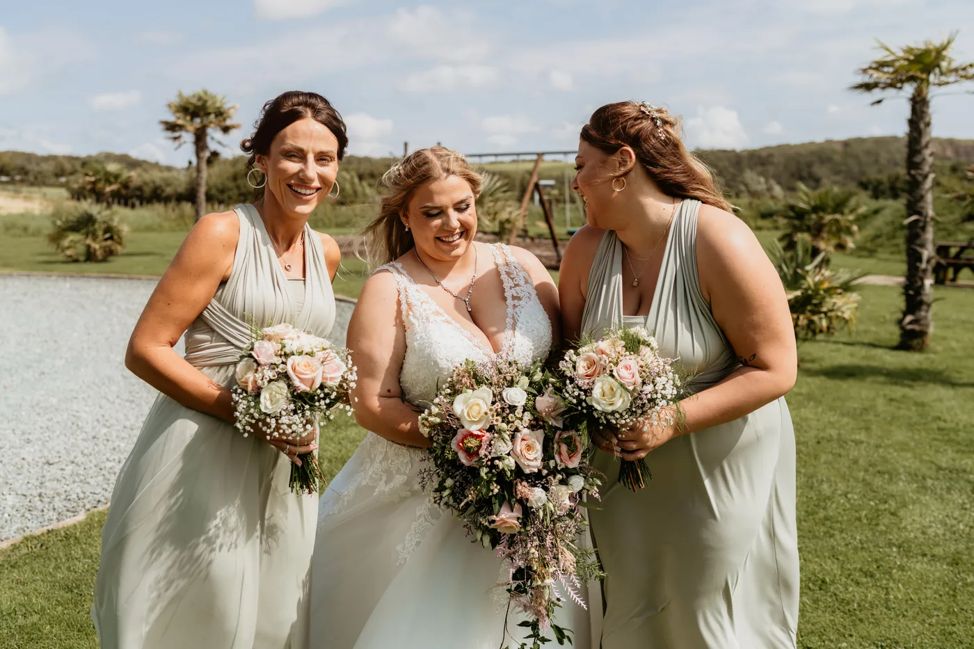 A bride with her bridesmaids and their bouquets on the lawn