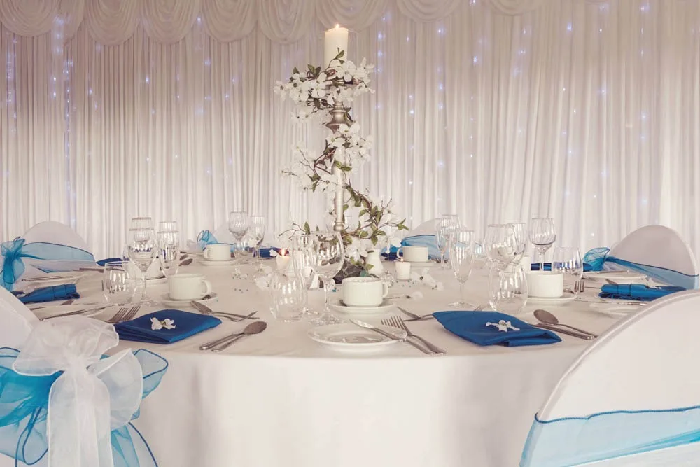 Round tables dressed with teal sashes for an intimate wedding