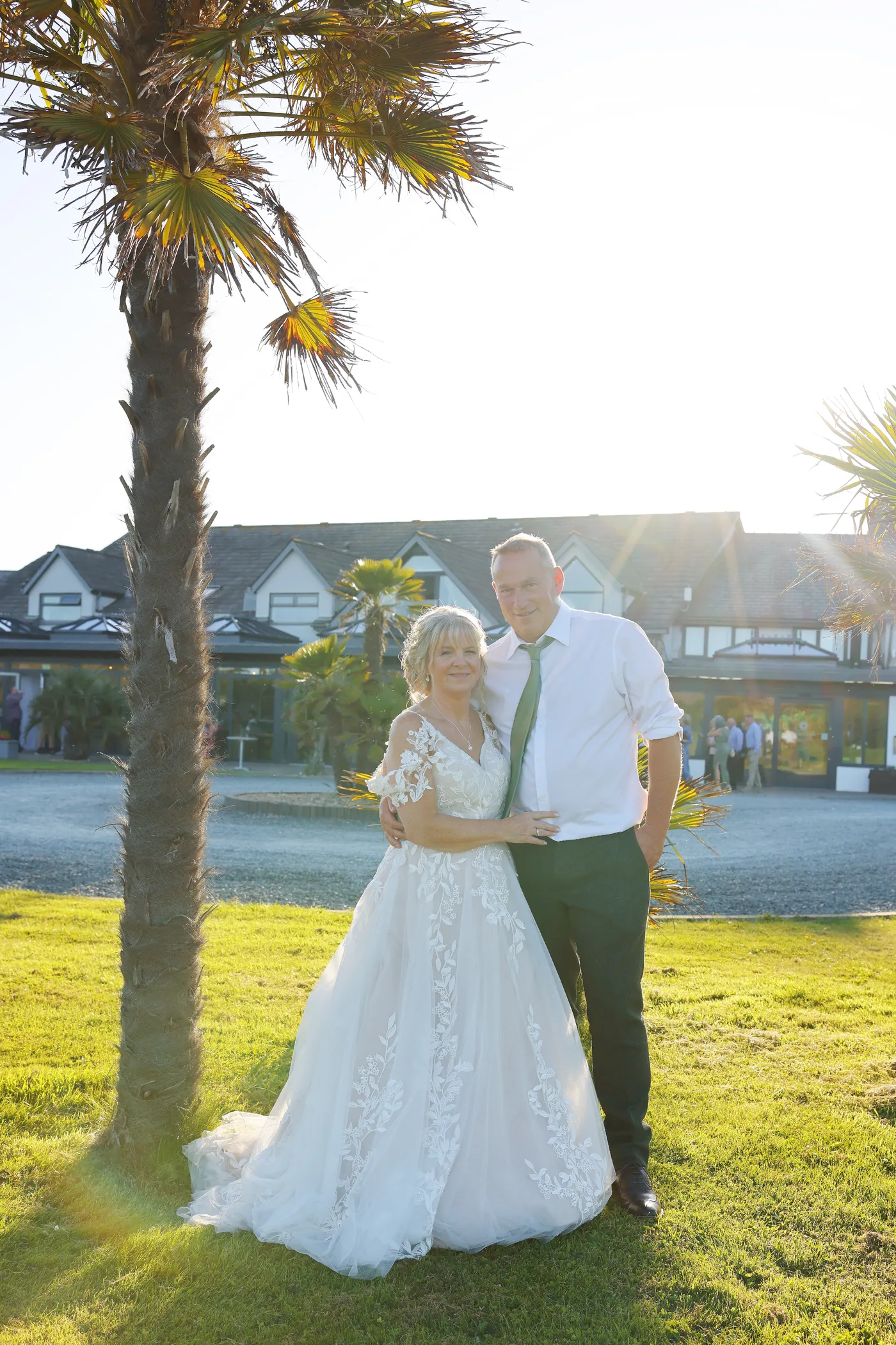 A couple together under the palm trees on the lawn