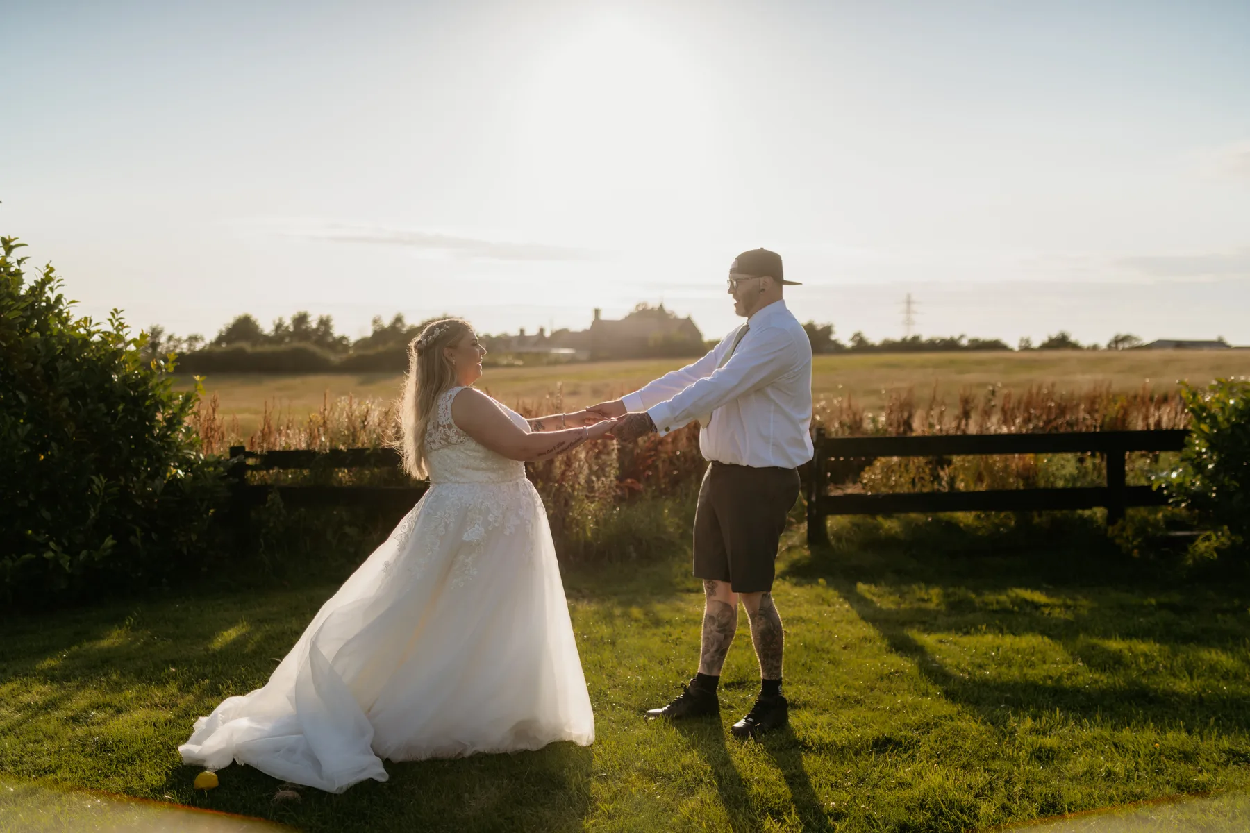A couple dancing in the field behind the hotel at golden hour