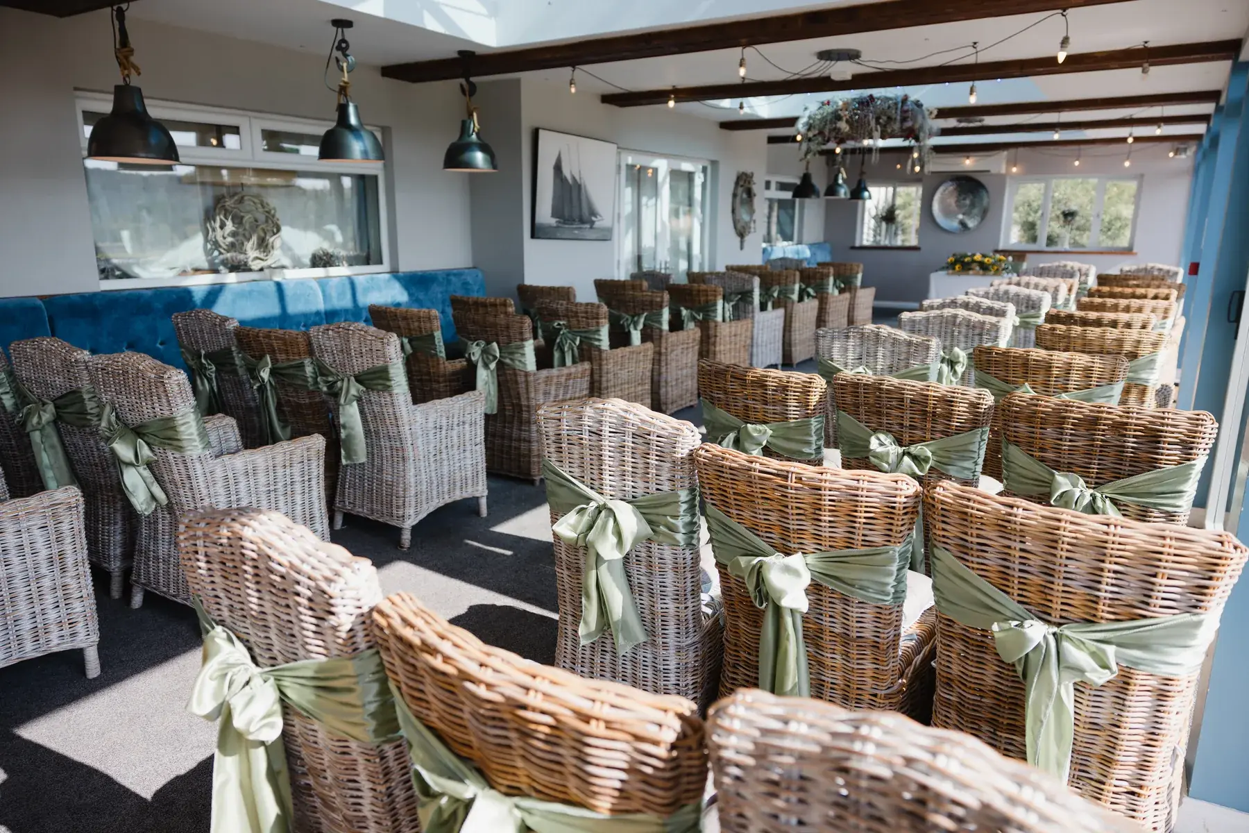 Wicker chairs with sage sashes set in rows in the Terrace Room