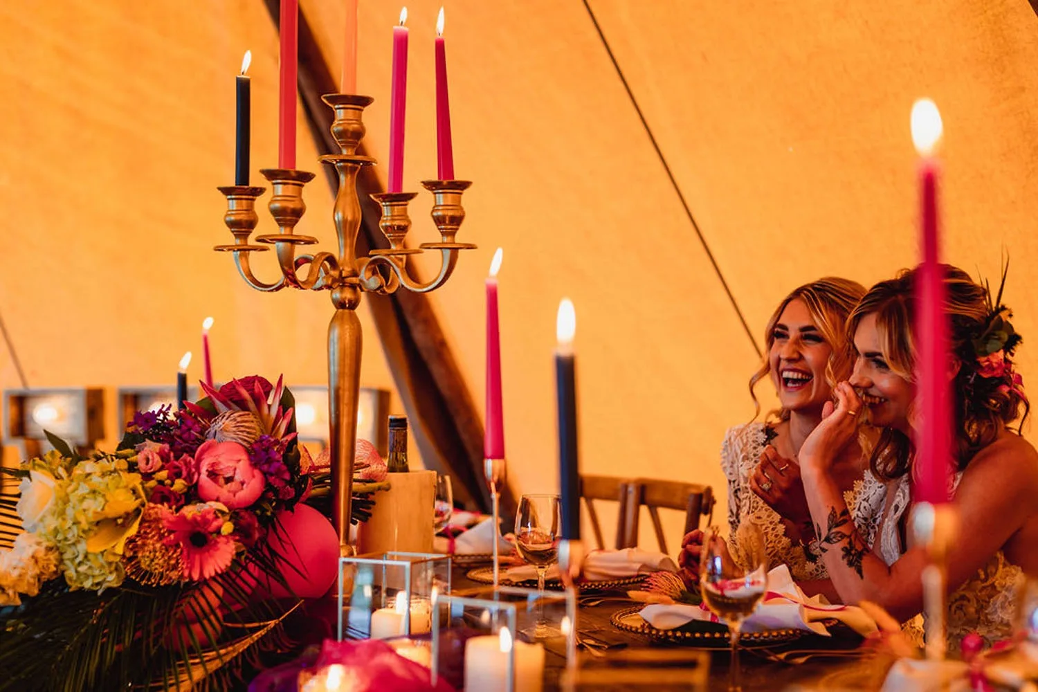 Guests around a candlelit table inside one of our tipis