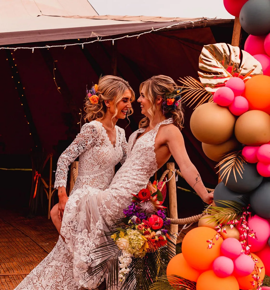 Two brides celebrating inside a tipi